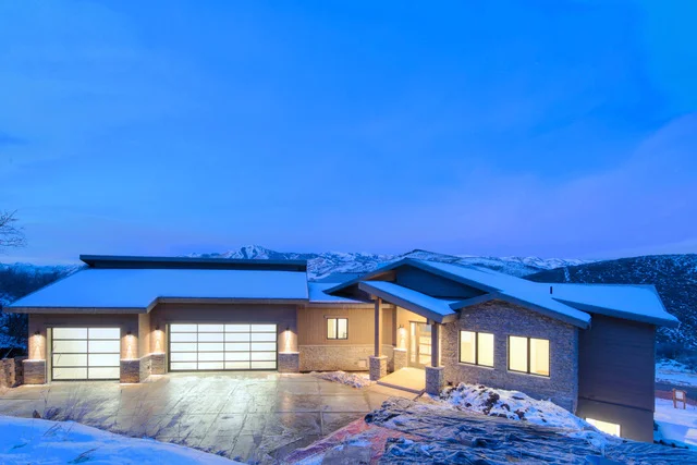 Deer Mountain luxury custom home exterior at twilight with stone accents and mountain views - Park City by Aspen Ridge Development