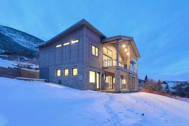 Rear elevation of two-story Deer Mountain custom home at twilight, Park City