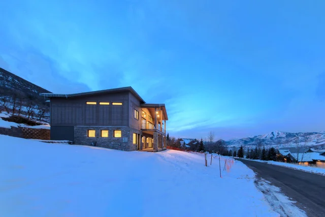 Side and driveway view of Deer Mountain custom home at dusk, Park City