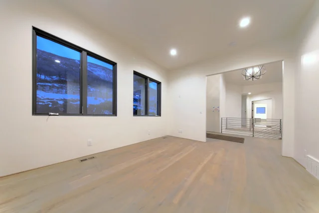 Upper hallway with chandelier and metal staircase in Deer Mountain custom home, Park City