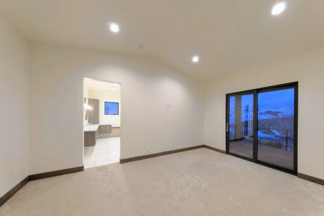 Master bedroom with slider to balcony in Deer Mountain custom home, Park City