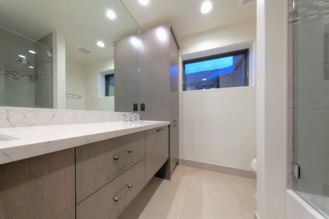 Guest bathroom with single vanity and glass shower in Deer Mountain custom home, Park City