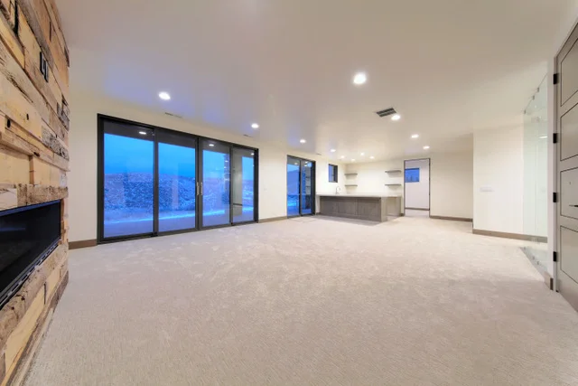Basement family room with reclaimed wood fireplace in Deer Mountain custom home, Park City