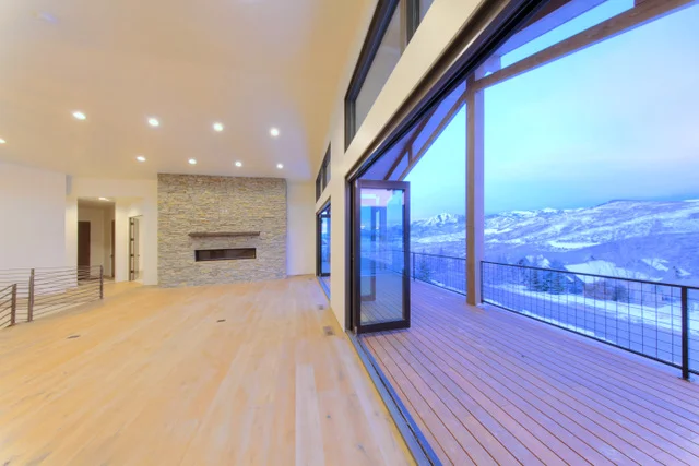 Great room toward deck with stone fireplace in Deer Mountain custom home, Park City