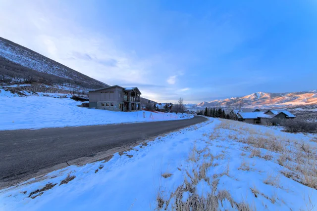 Property street view with curving road at Deer Mountain custom home, Park City