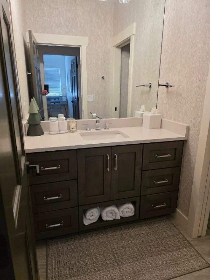 Guest bathroom vanity with dark wood cabinets and white quartz top in Deer Valley