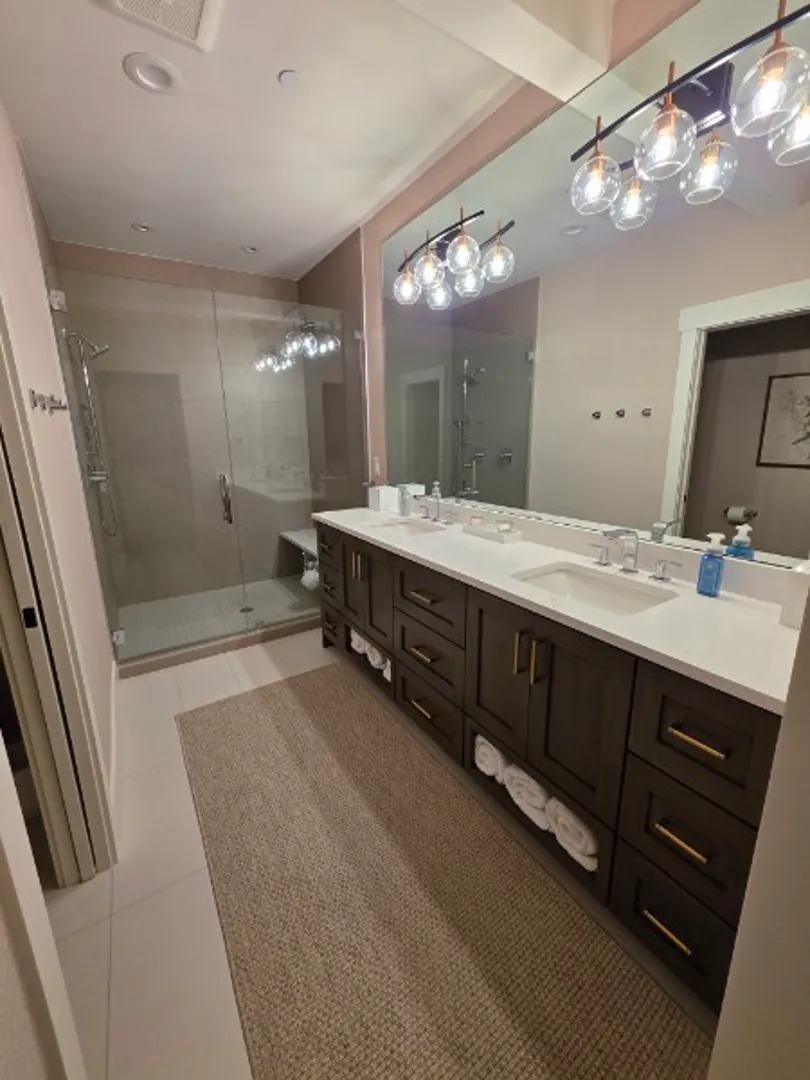 Master bathroom with dual vanity, glass shower, and globe lights in Deer Valley