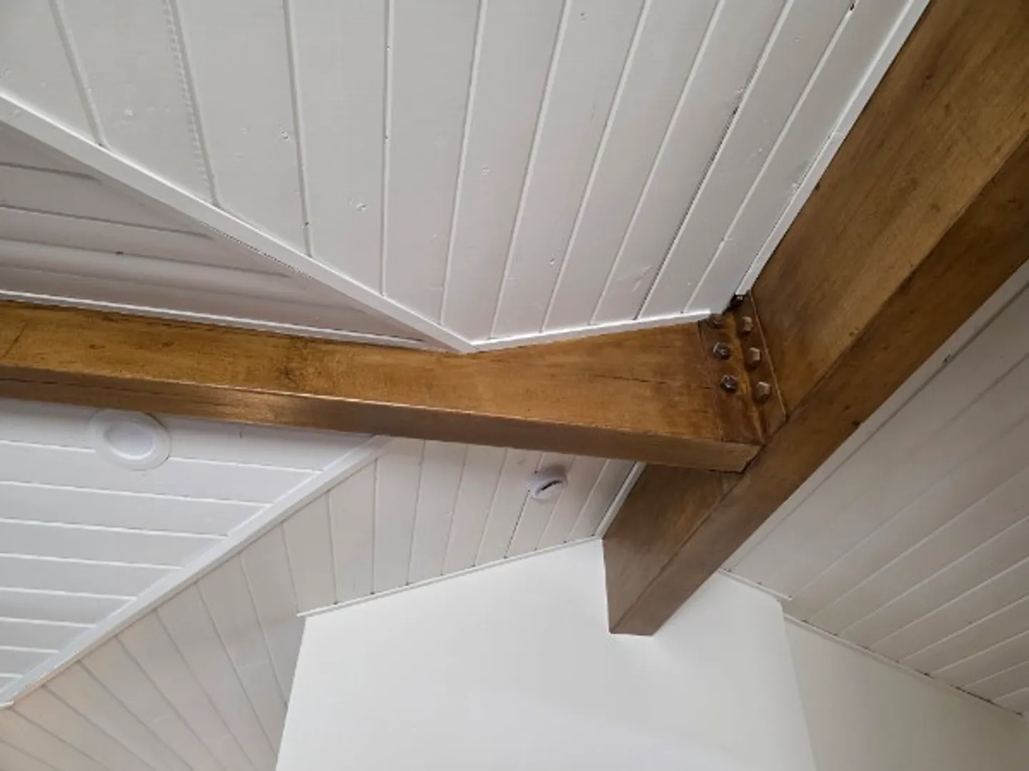 Vaulted ceiling detail with rustic wood beams and white shiplap paneling in Deer Valley remodel