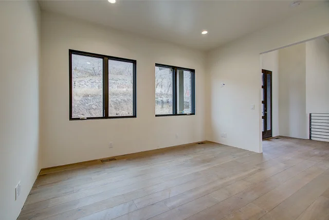 Bedroom with hardwood floors and black-framed windows in Slalom Run custom home Park City