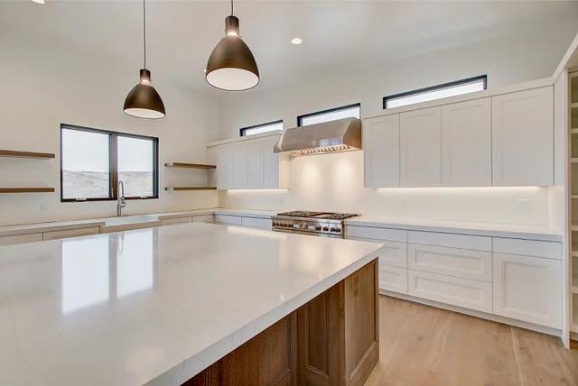 Kitchen alternate angle showing pendant lights, wood island, and farmhouse sink in Park City home