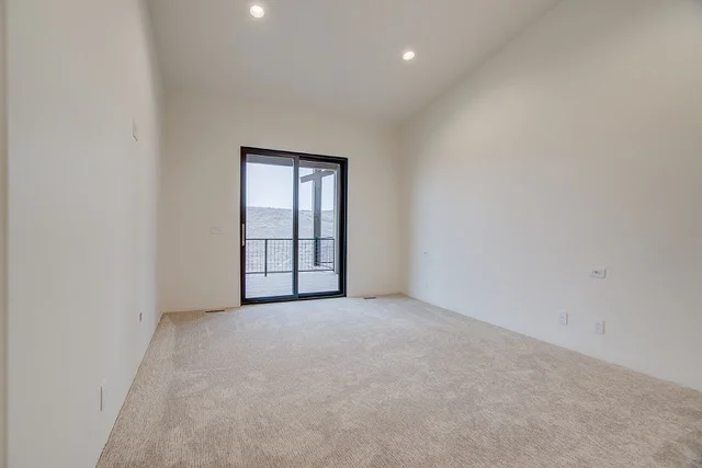 Bedroom with sliding door to balcony and vaulted ceiling in Slalom Run home