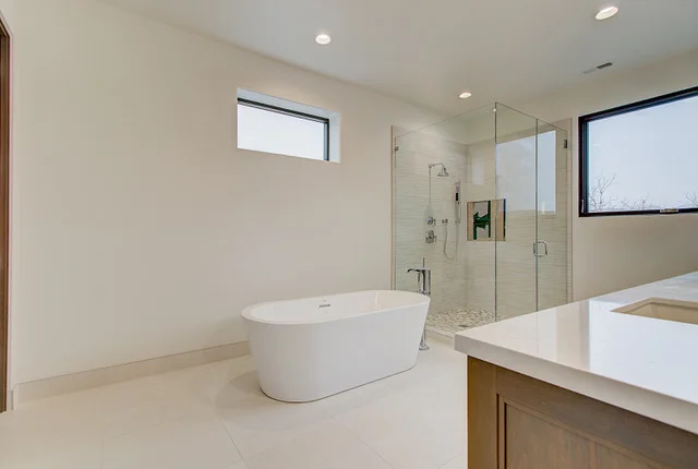 Bathroom with freestanding tub, glass shower, and light wood vanity in Park City custom home