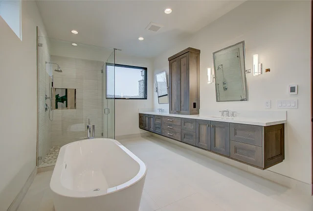 Bathroom with freestanding tub, dark wood vanity, and wall sconces in Slalom Run