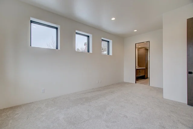 Carpeted bedroom with three small windows and en-suite doorway in Slalom Run