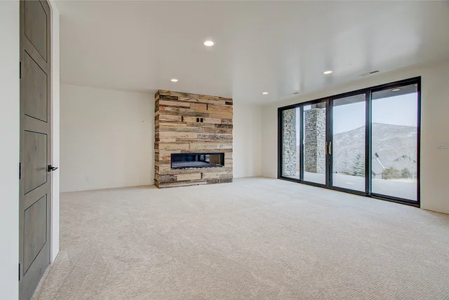 Basement family room with reclaimed wood fireplace and sliding doors in Slalom Run