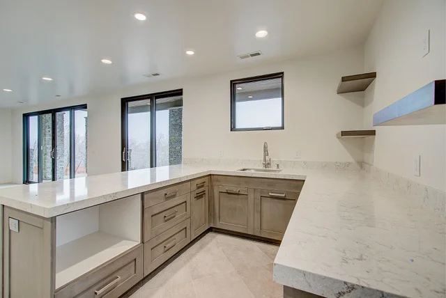 Wet bar with quartz counter, wood cabinets, and shelves in Slalom Run basement