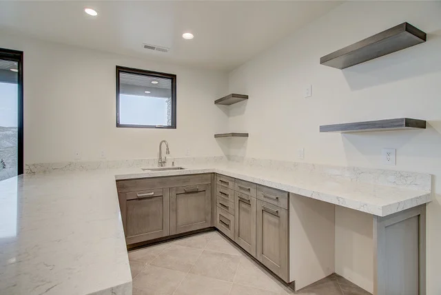 Basement wet bar detail with corner sink and marble counter in Park City home
