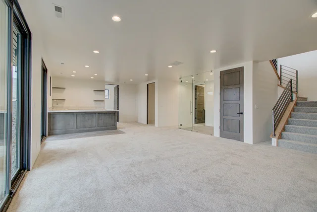 Basement open plan with wet bar, staircase, and sliding doors in Slalom Run luxury home