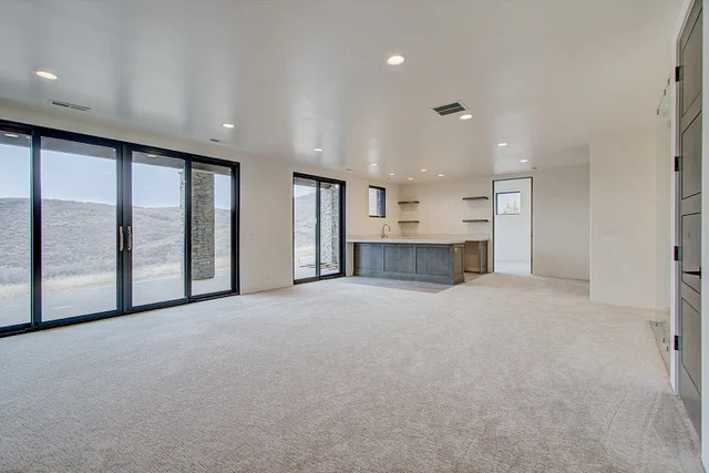 Basement with sliding doors to patio, wet bar, and mountain views in Park City