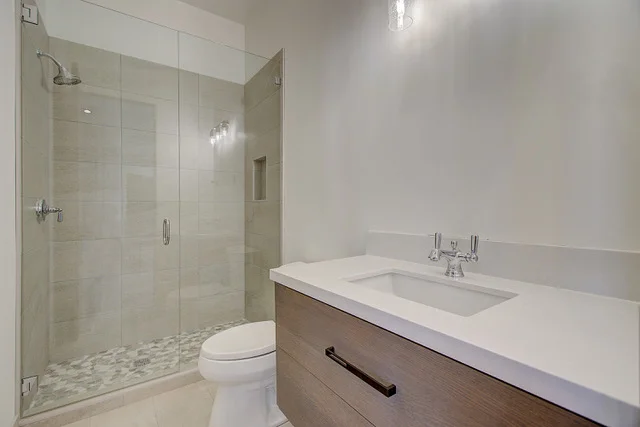Guest bathroom with glass shower, tile work, and floating vanity in Slalom Run home