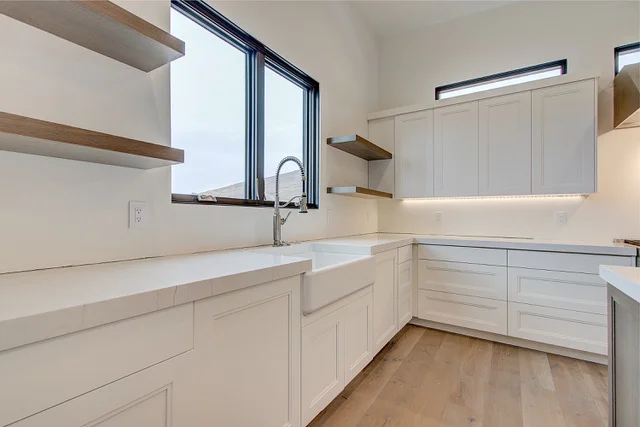 Kitchen pantry area with farmhouse sink, commercial faucet, and floating shelves in Park City